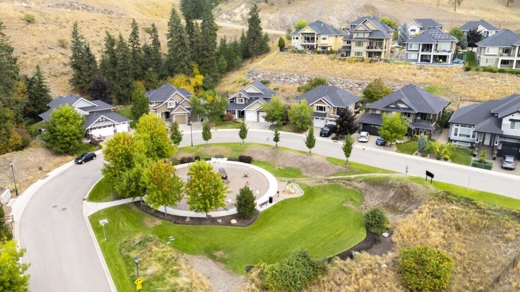 Aerial view of a curved residential cul-de-sac with a landscaped green at its centre and houses around the loop.