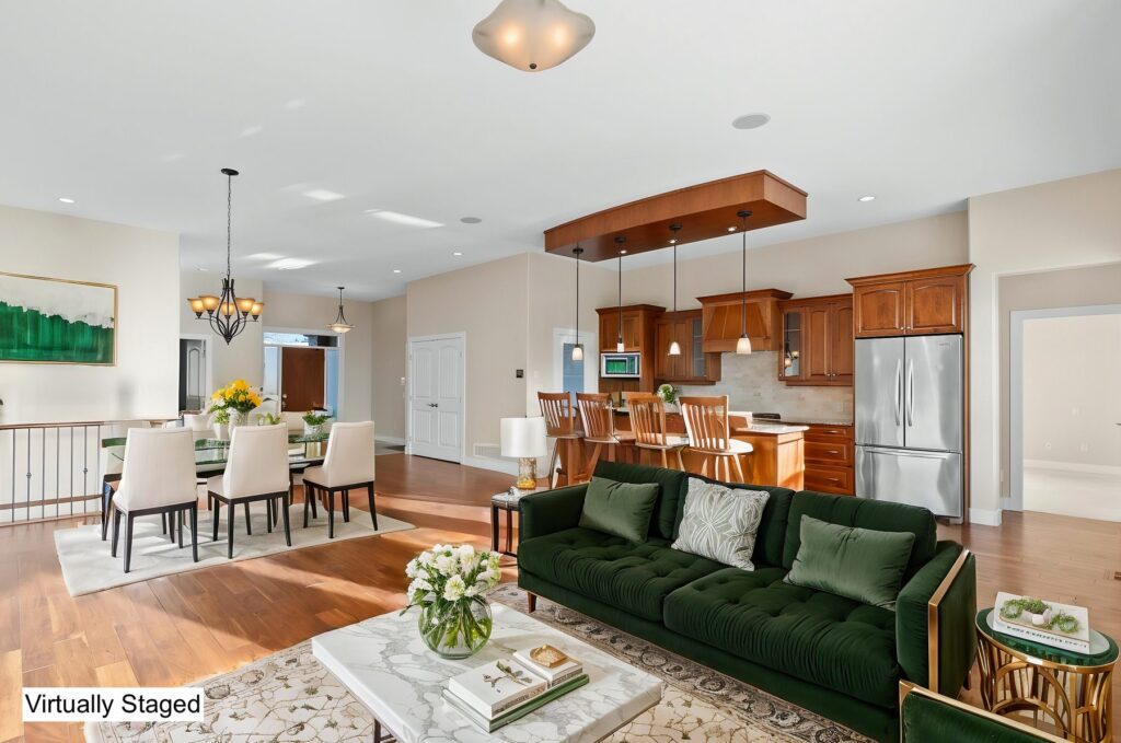 The same empty living area shown with a green sofa, rug, dining table and accessories added digitally; the image carries a Virtually Staged label.