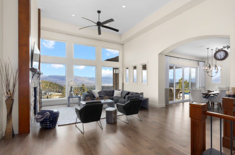 Great room with floor-to-ceiling windows looking over the Okanagan valley in a Kelowna home