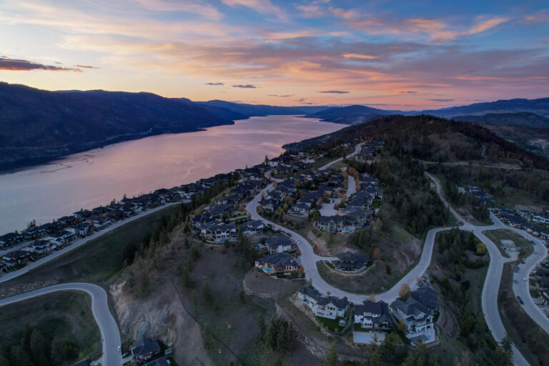 Aerial view at twilight of a Kelowna hillside community above Okanagan Lake